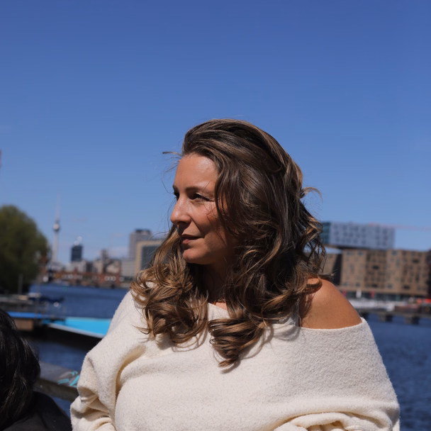 Sarah-Lisa Besemer steht im Sonnenlicht am Spreeufer in Berlin.