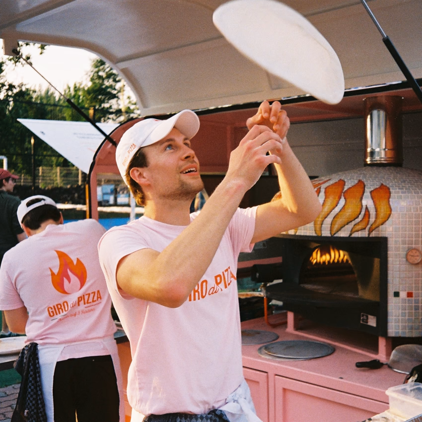 Anton Calamita wirft an seiner Pizza-Ape einen Pizzateig in die Luft.