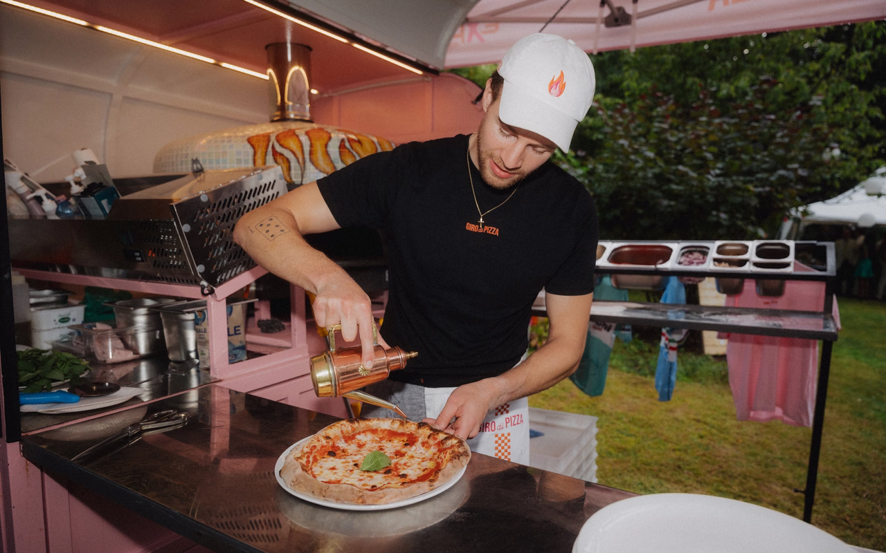 Anton Calamita beträufelt in seiner Ape eine frisch gebackene Margherita mit Olivenöl.