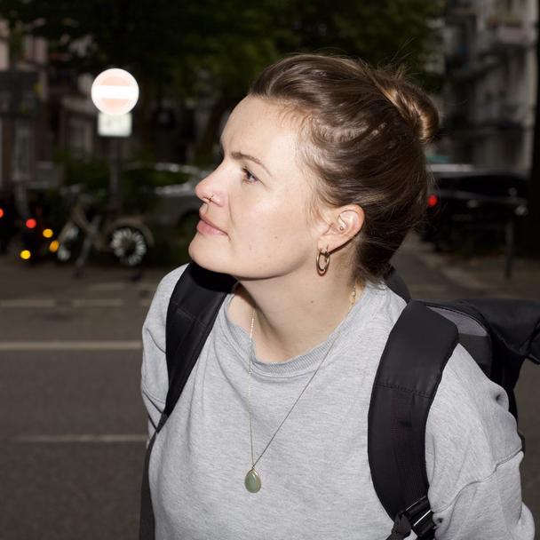 Melanie Wildt im Profil auf einer Straße, im Hintergrund Einbahnstraßenschilder.