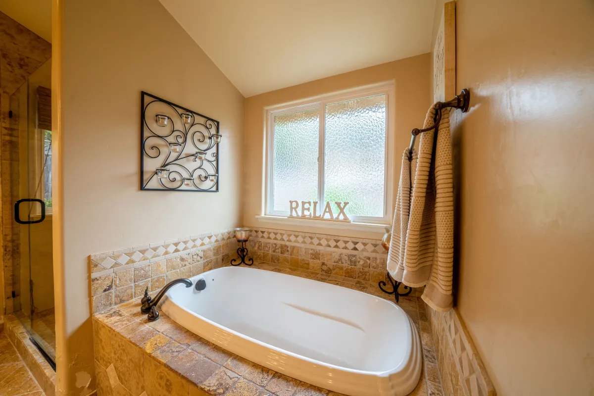 The inviting bathtub in the master suite, geared with plenty of candles and stone.