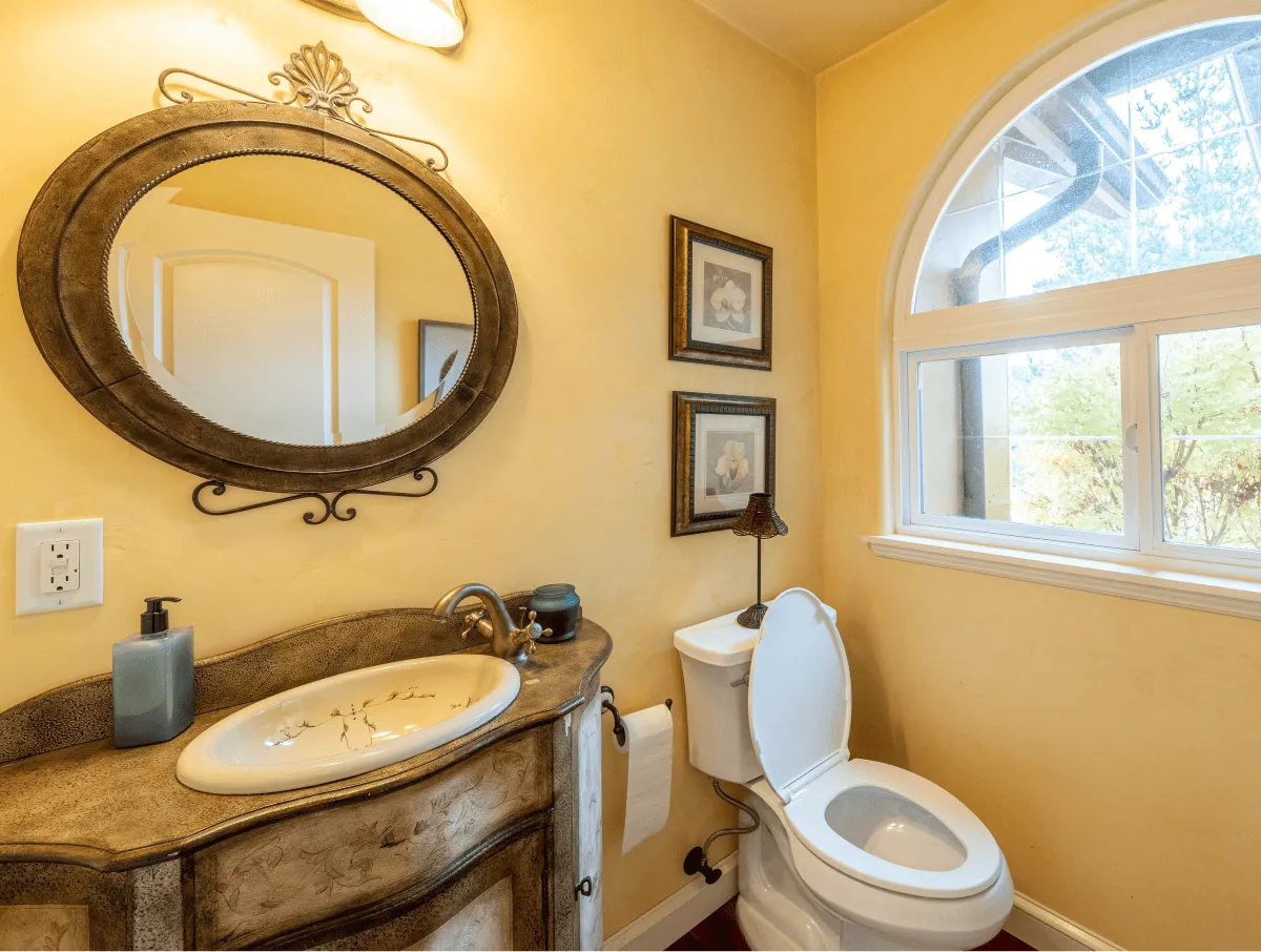 The half bath bathroom and it's elegant mirror and sink.