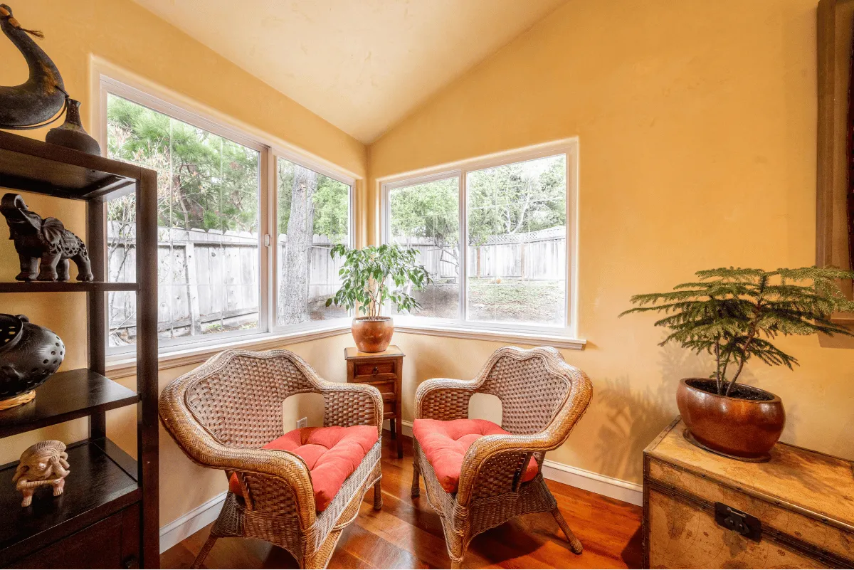 The peaceful reading nook of the living room with ratan chairs and a lot of natural light.