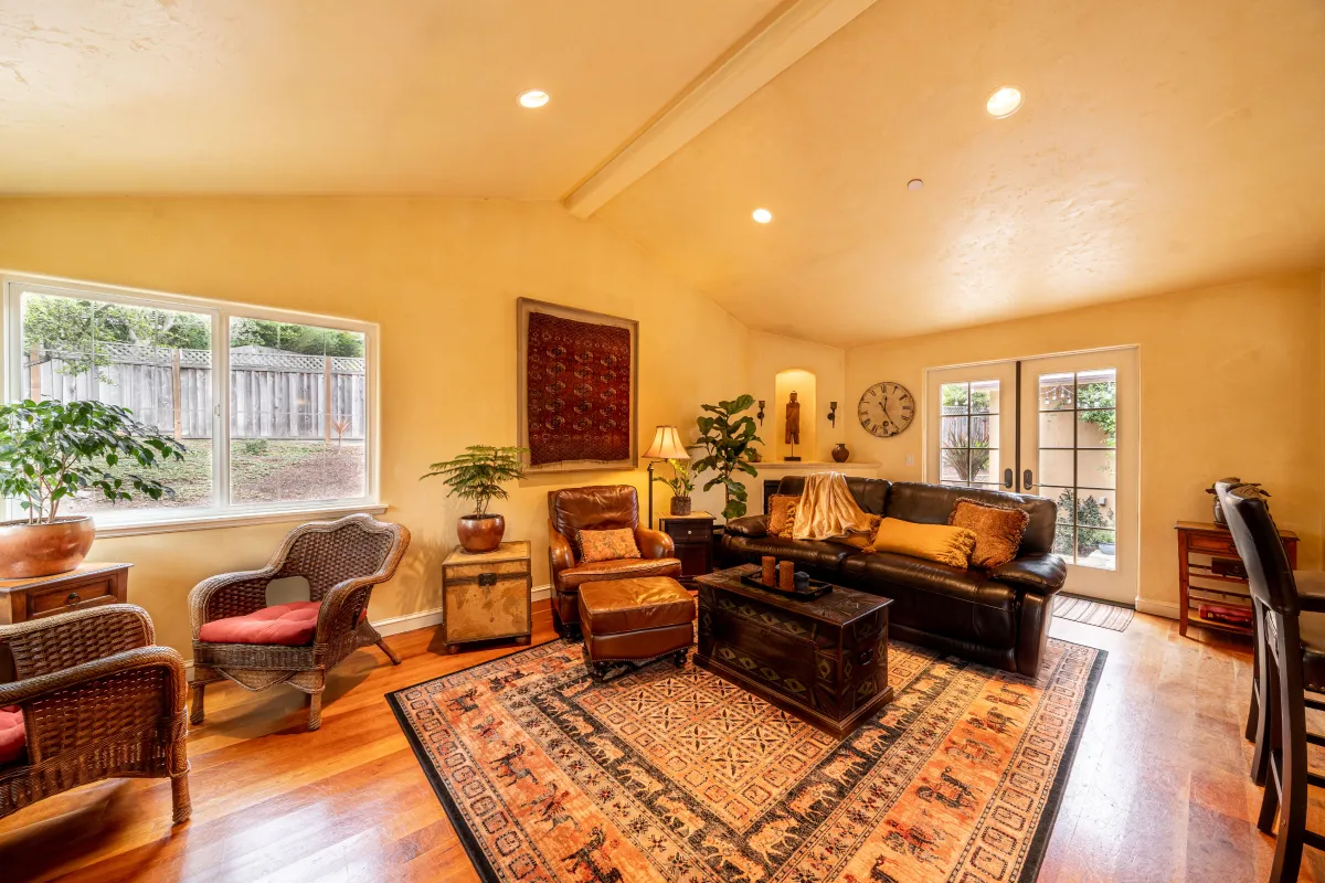 A wide view of the warm tuscan looking living room with plenty of space and seating.
