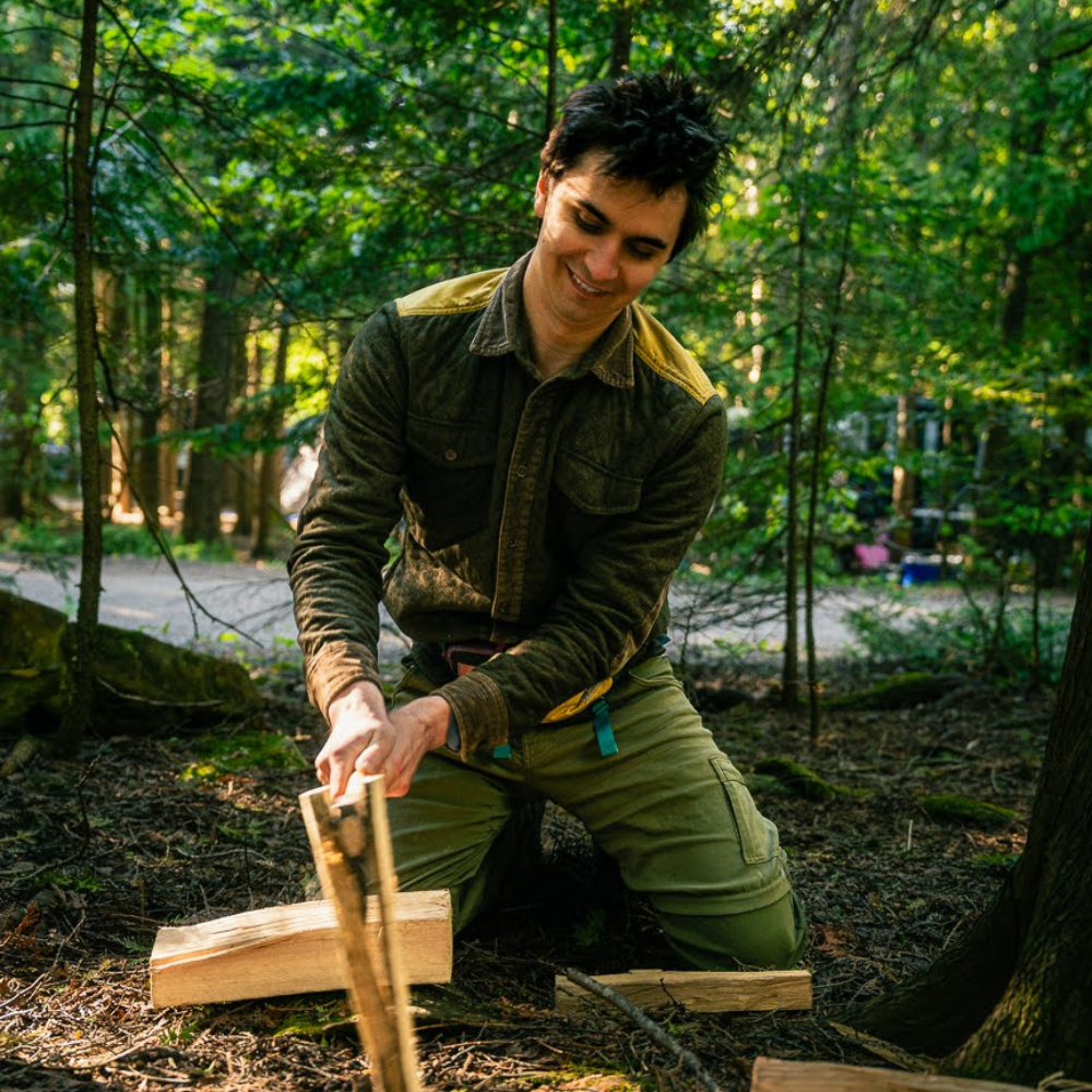 Splitting firewood with a knife by batoning in the forest