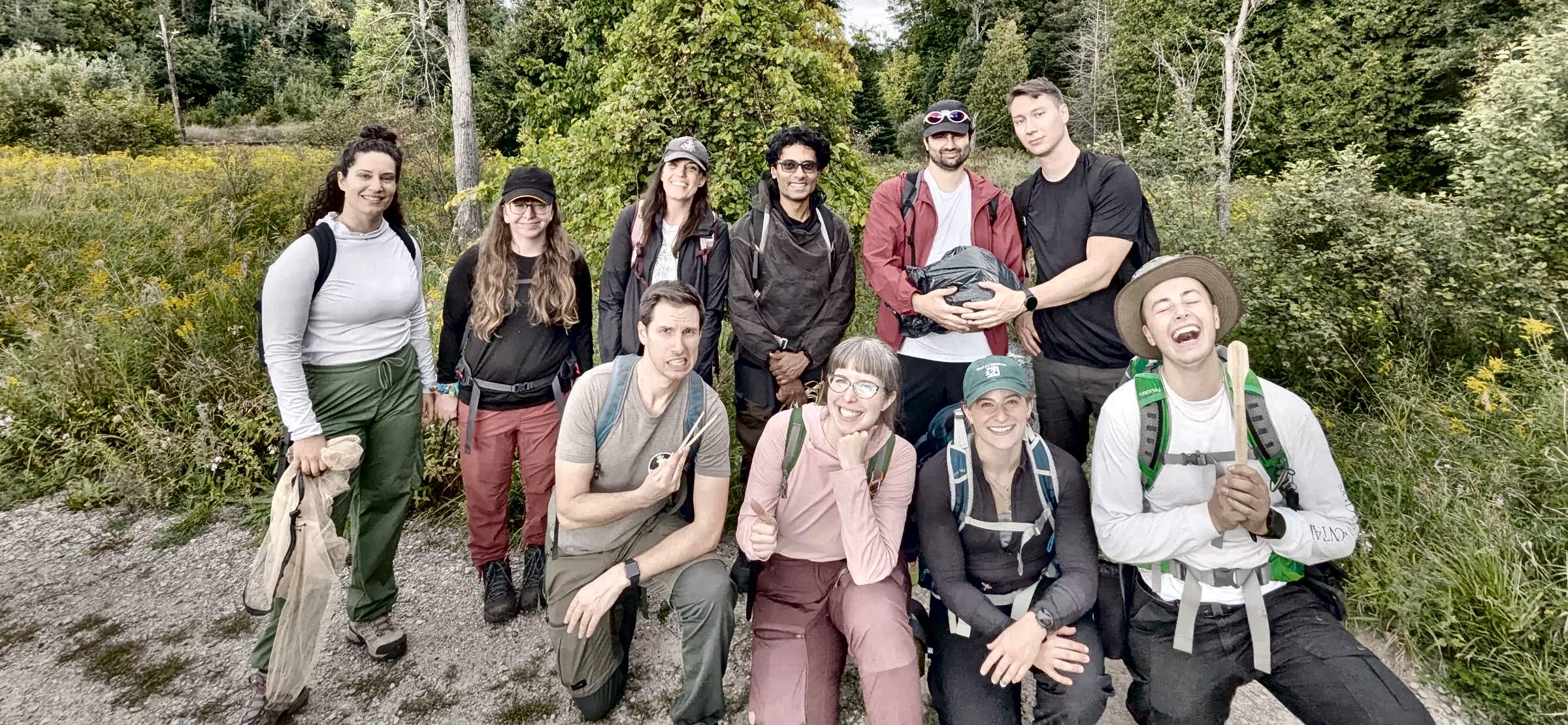 A Survival Skills course group smiling together at the edge of a meadow