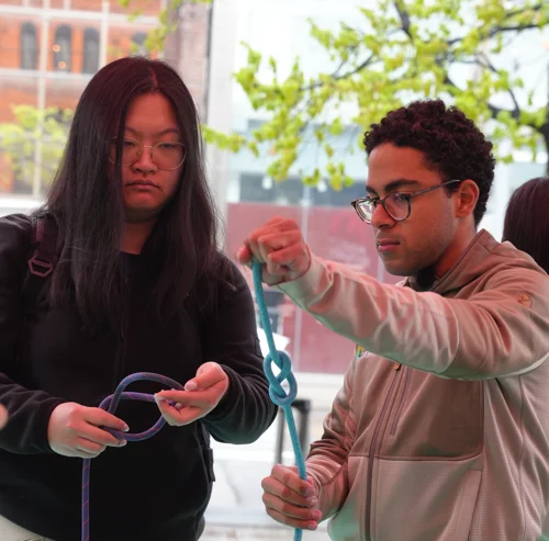 Two course participants practising knots with rope