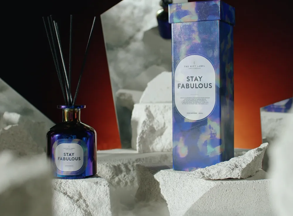 Luxe geparfumeerde diffuser en verpakking van The Gift Label met de tekst 'Stay Fabulous', gepresenteerd op witte rotsen.