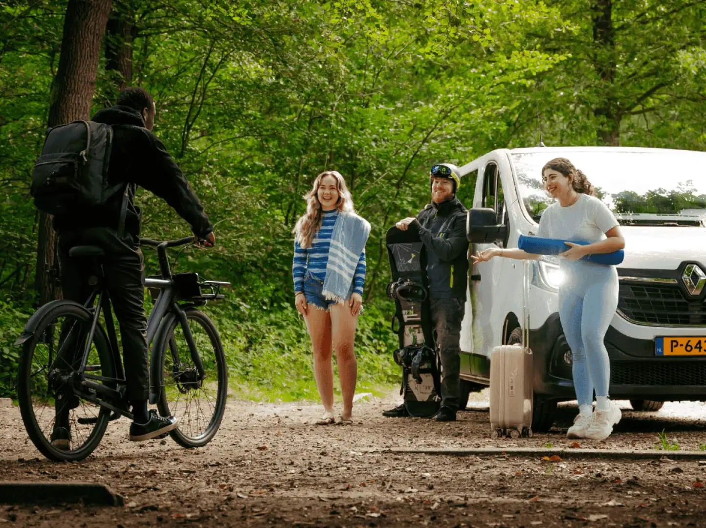 Vier mensen staan buiten in een bos en die moeten lagen om een jongen die komt aan fietsen