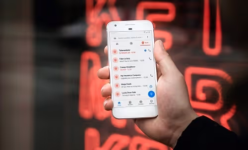Person holding a smartphone showing a call log and spam call list
