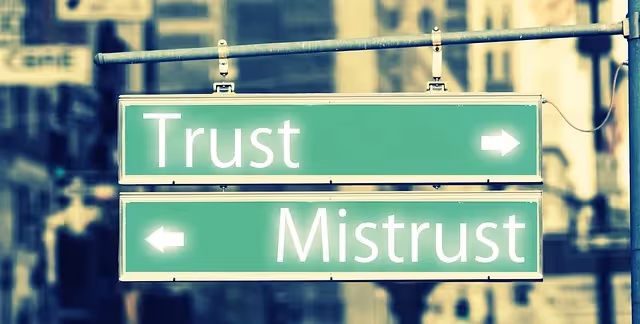 Street sign with arrows labeled “Trust” and “Mistrust” pointing in opposite directions.