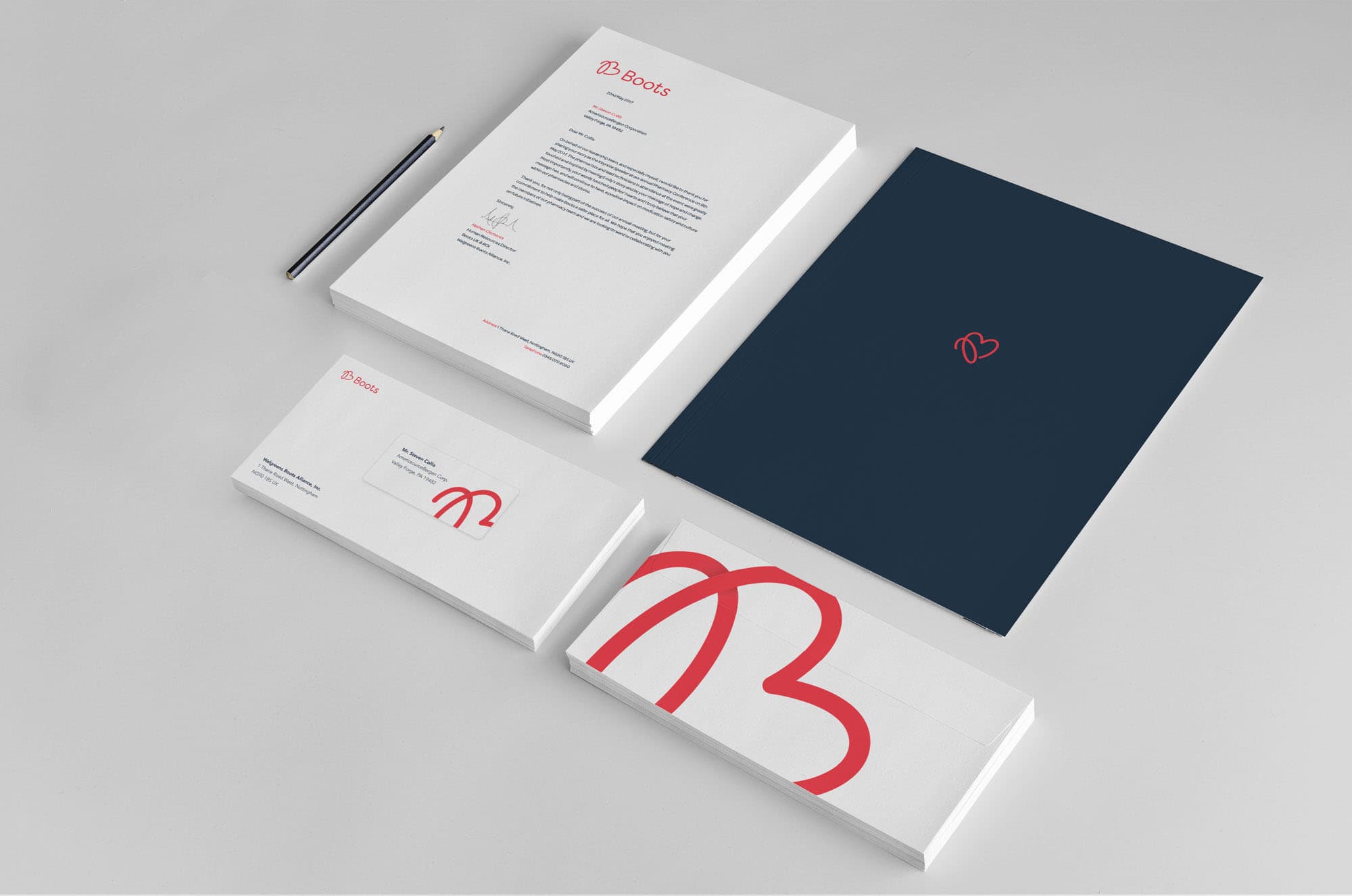 Boots stationery showing a blue folder with the heart logo, a letterhead, and envelope designs.