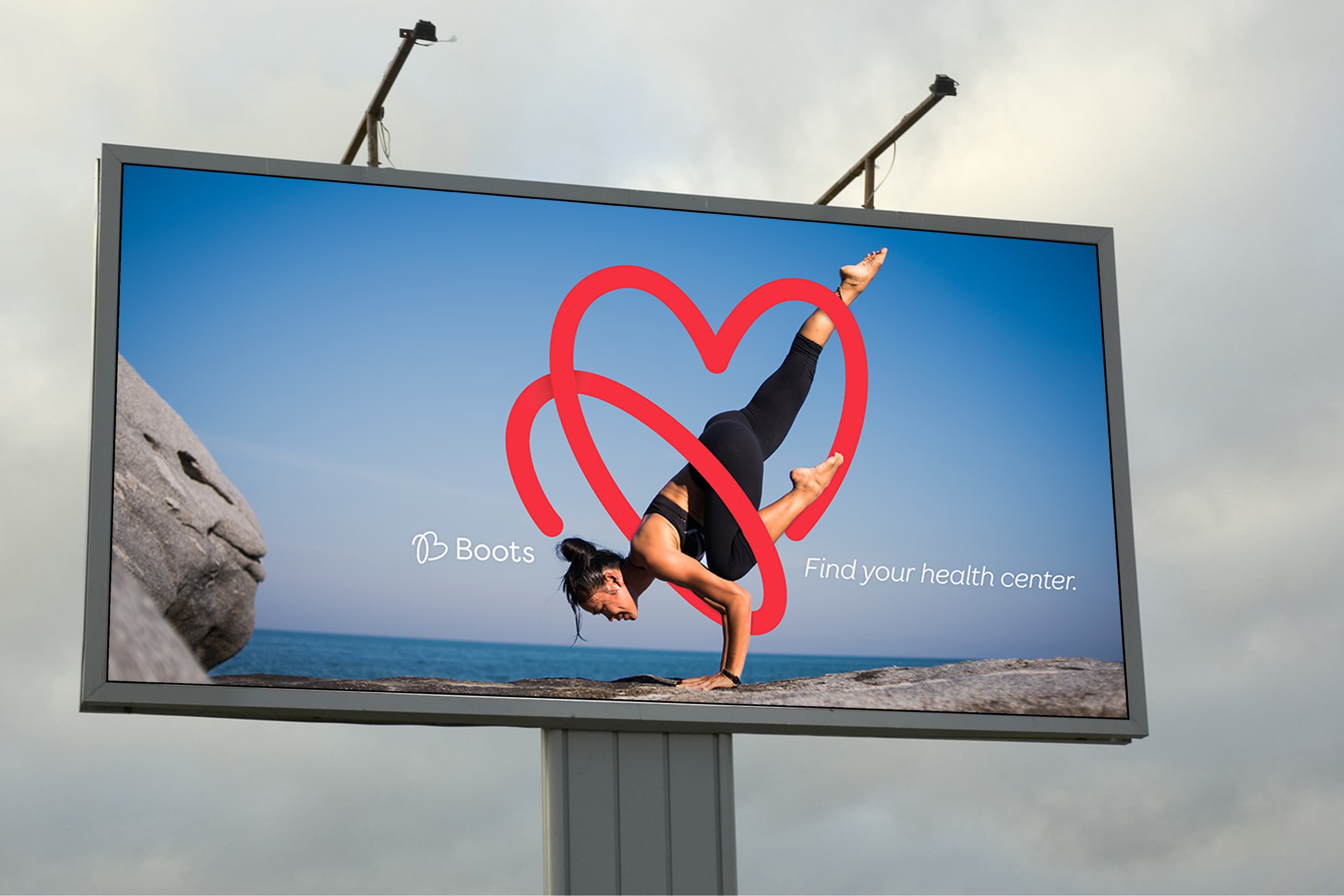 A billboard for Boots, showing a girl in a yoga pose, with the heart logo wrapping around her body.