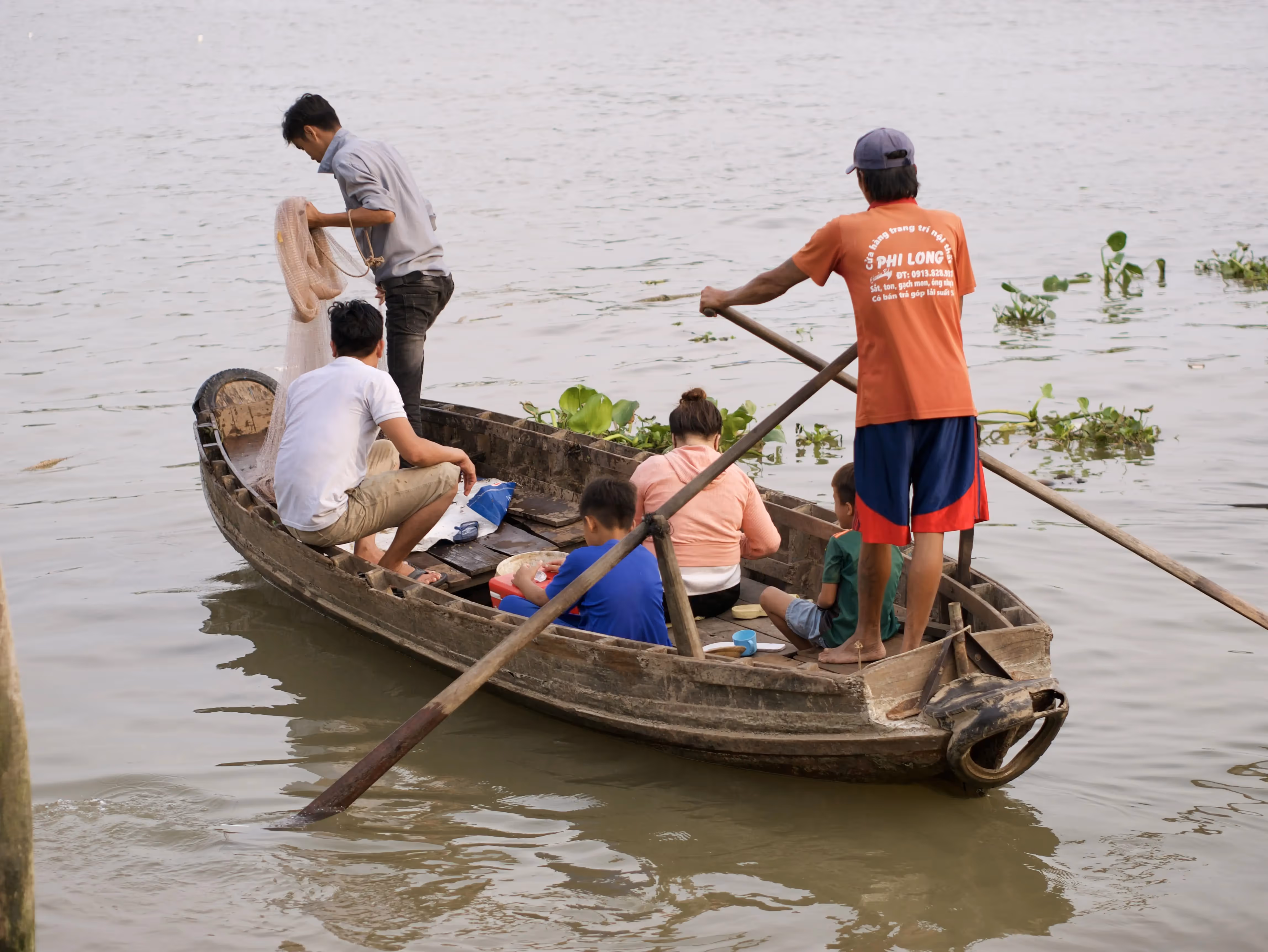Une famille sur un radeau en bois à Can Tho, Vietnam