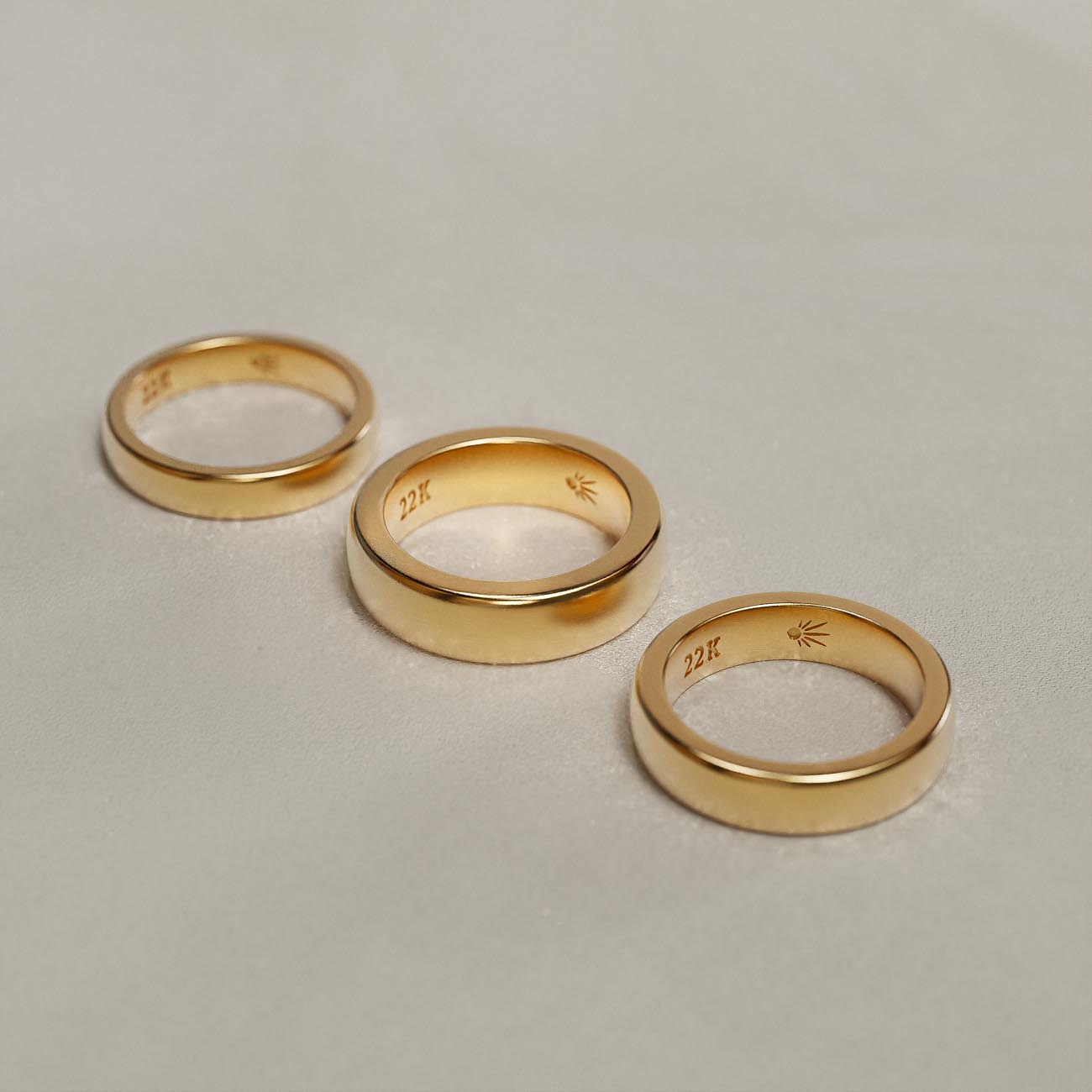 Die Hände eines heiratenden Paares mit Goldringen aus 22K