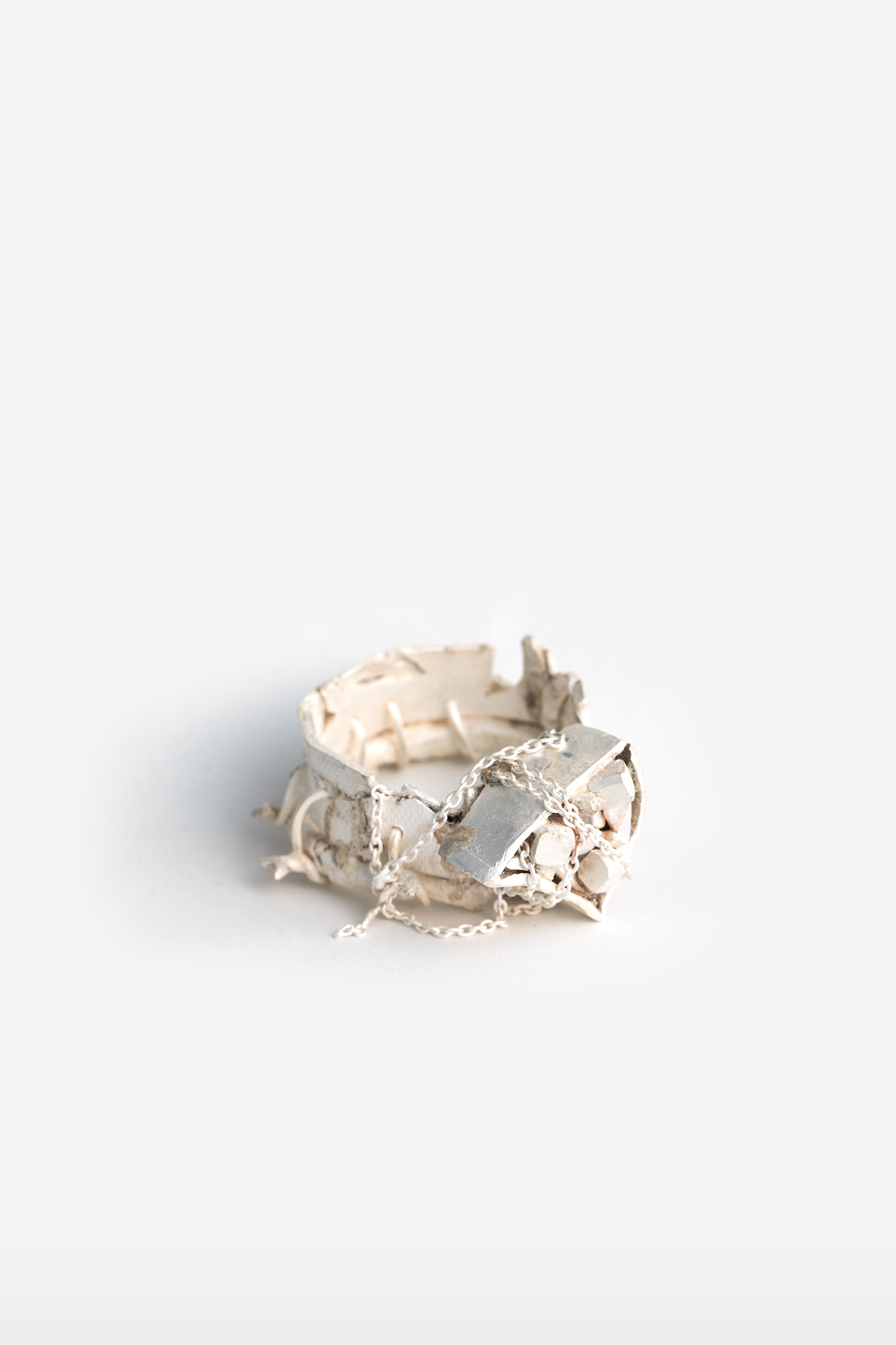 silber ring mit ungewöhnlicher textur und einzelnen silber stücken und verstecktem edelstein