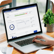 Laptop screen displaying a real-time analytics dashboard with charts and statistics, a hand holding a stylus near the keyboard.