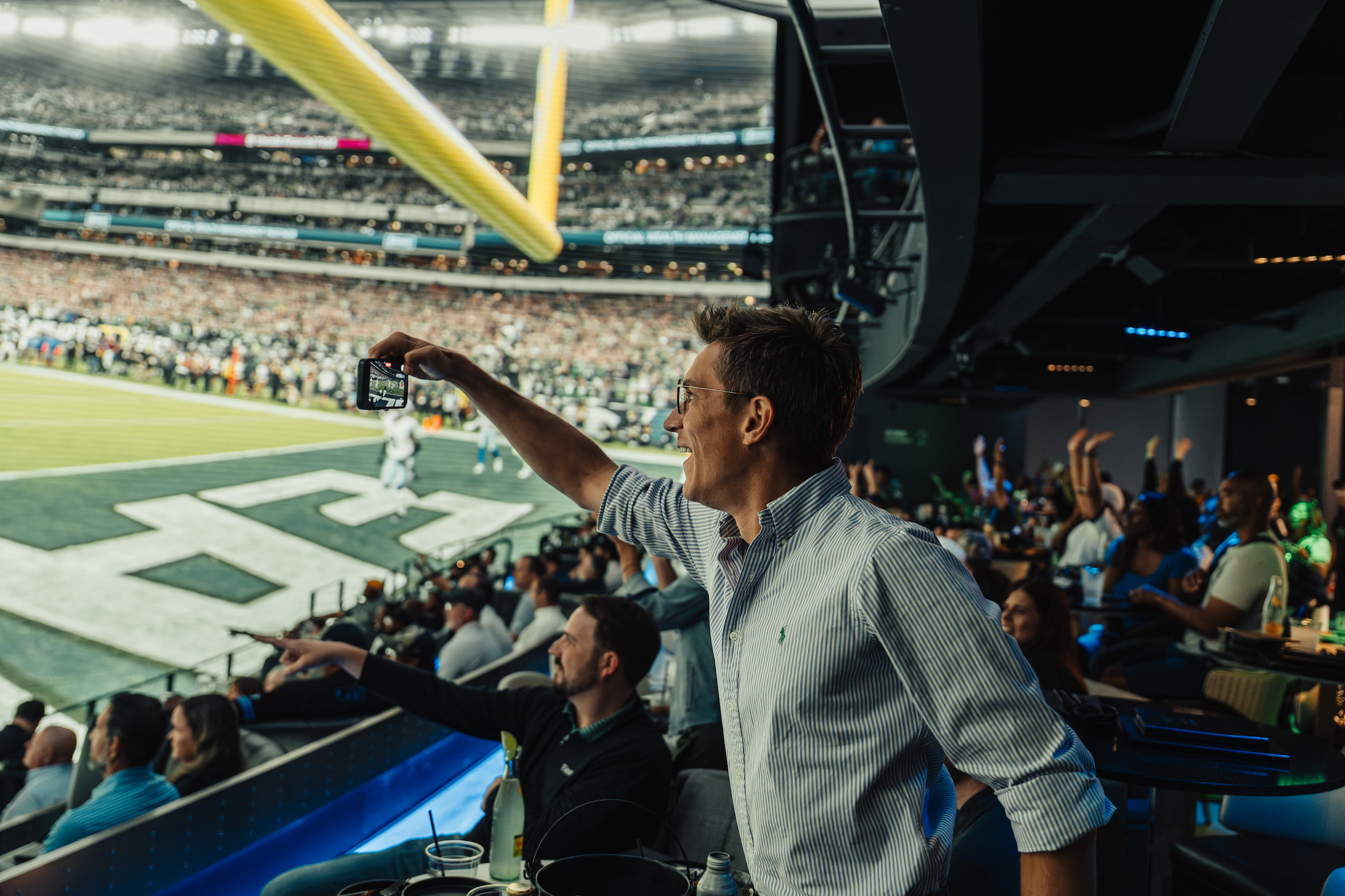 An NFL fan taking a picture of the immersive dome at Cosm.