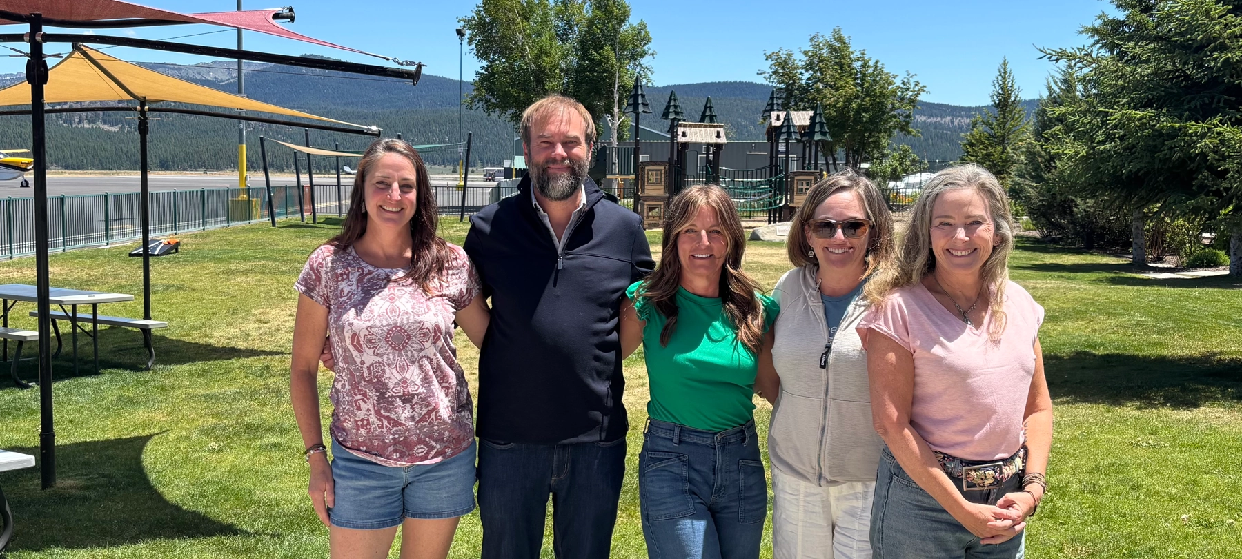 Five people standing at the Truckee Airport park.