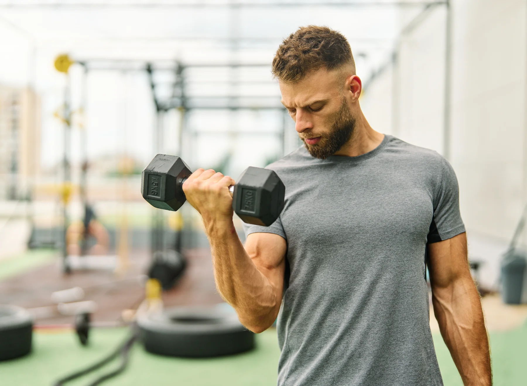 Junger Mann beim Krafttraining der Arme – Sport als natürlicher Weg, die Potenz zu steigern. | GoSpring