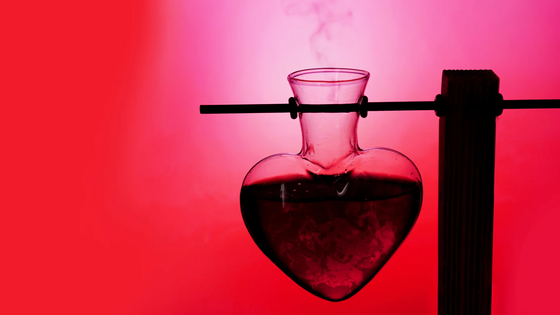 Herzförmiges Glasgefäß mit roter Flüssigkeit als Symbol für Aphrodisiaka und Liebestränke. | GoSpring