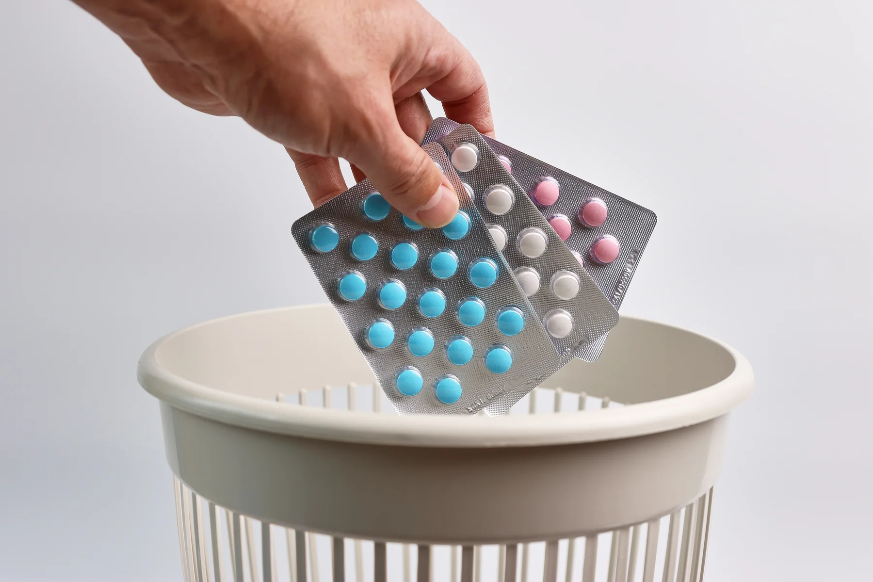 Blisterpackungen mit blauen Tabletten über Mülleimer – Risiken des Freizeitgebrauchs von PDE-5-Hemmern. | GoSpring