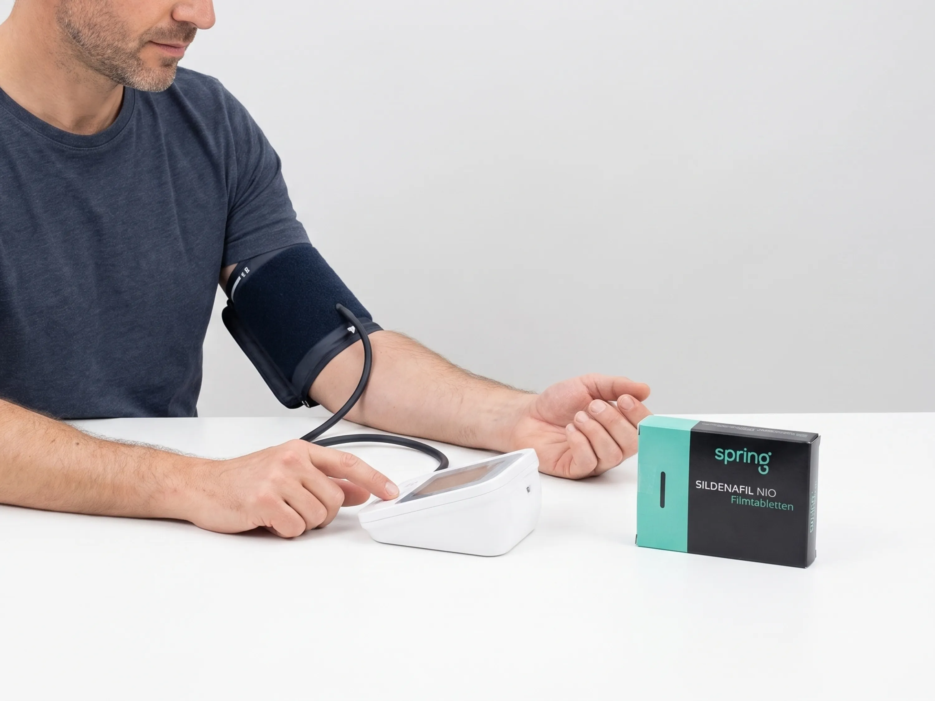 Sildenafil NIO Filmtabletten von GoSpring neben einem Mann bei der Blutdruckmessung.