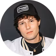 Portrait photo of Zach Justice wearing a black cap and white jacket, with his name 'Zach Justice' written below.