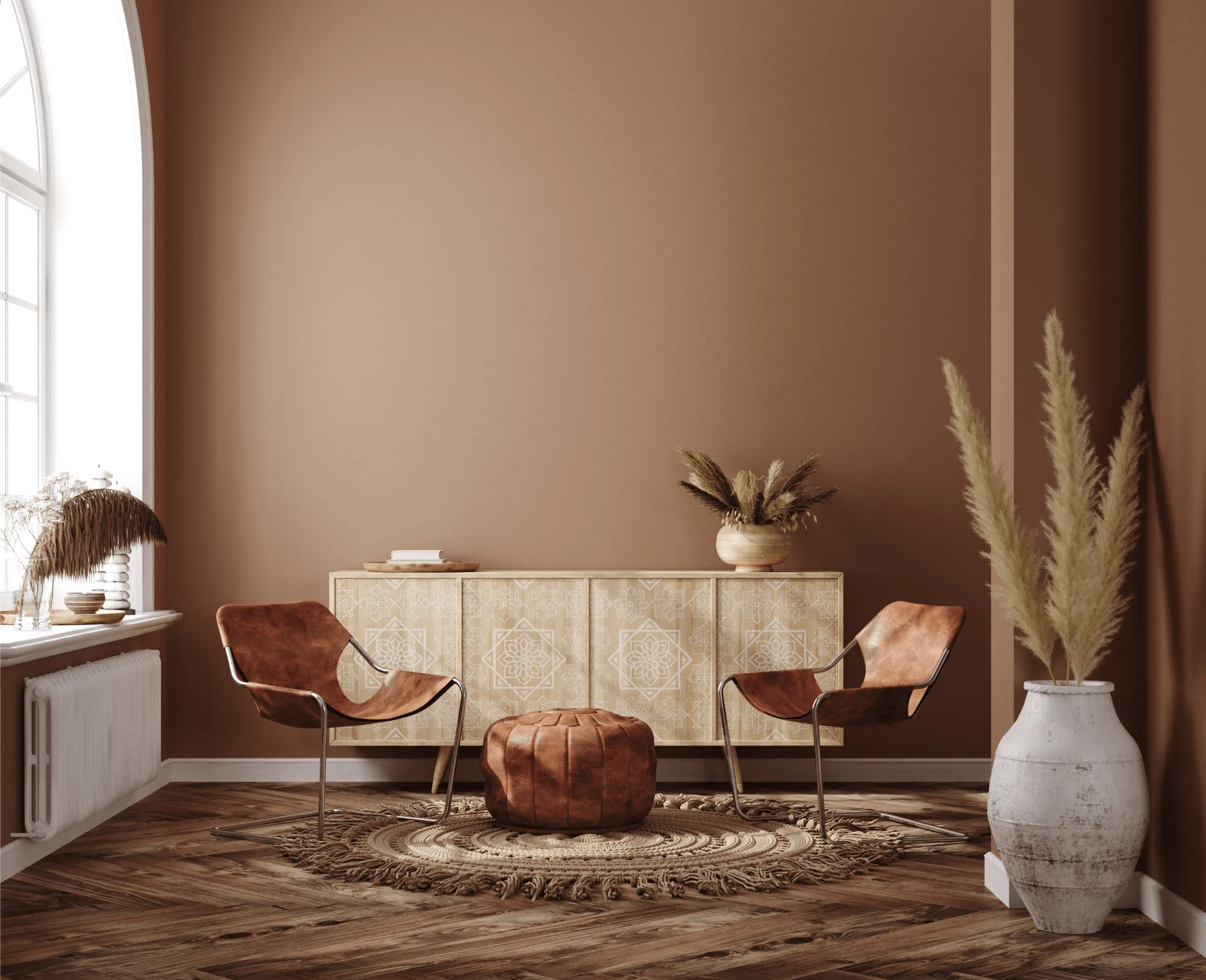 Woonkamer met een terracotta wand, een houten dressoir en leren fauteuils