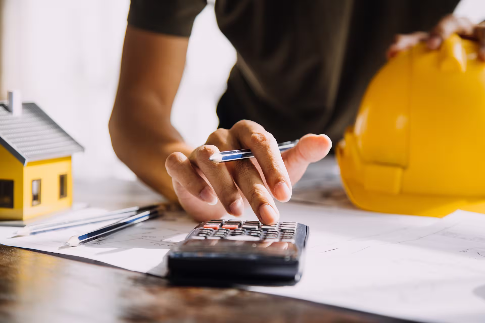 Homme sur le chantier faisant une facture sur son bureau