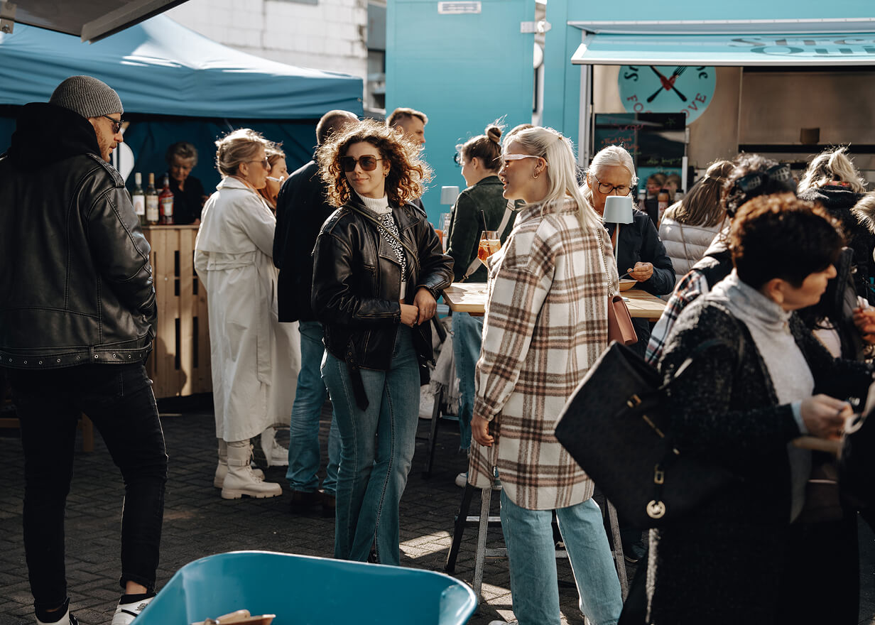 Menschen stehen bei einer Outdoor Abifeier vor dem Foodtruck von Streetquizine