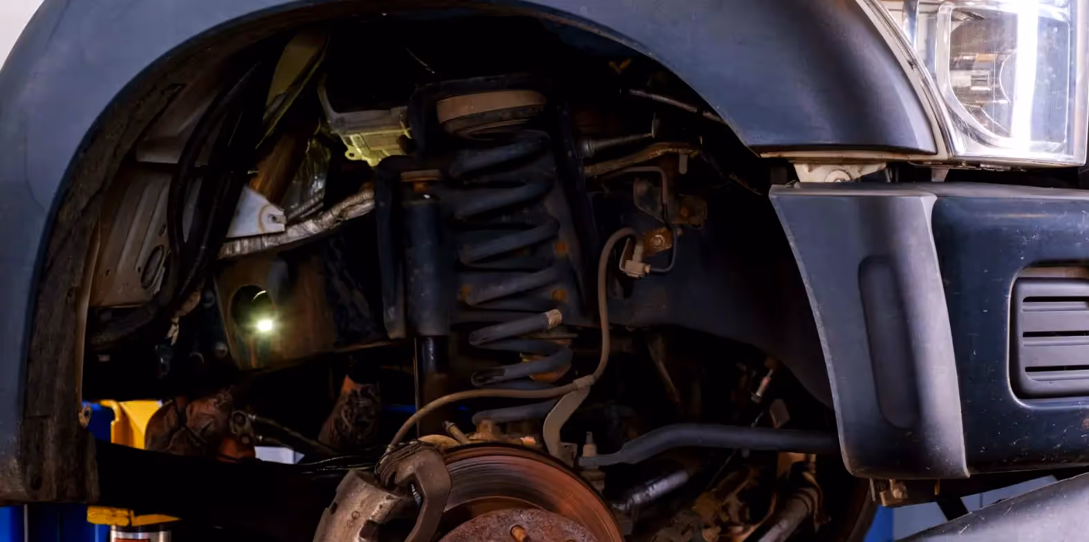 Mechanic performing truck suspension repairs from SOS Truck & Trailer Repair