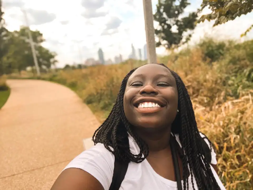 Tiktoker Riziki Ilenre smiles at the camera on a nature walk.