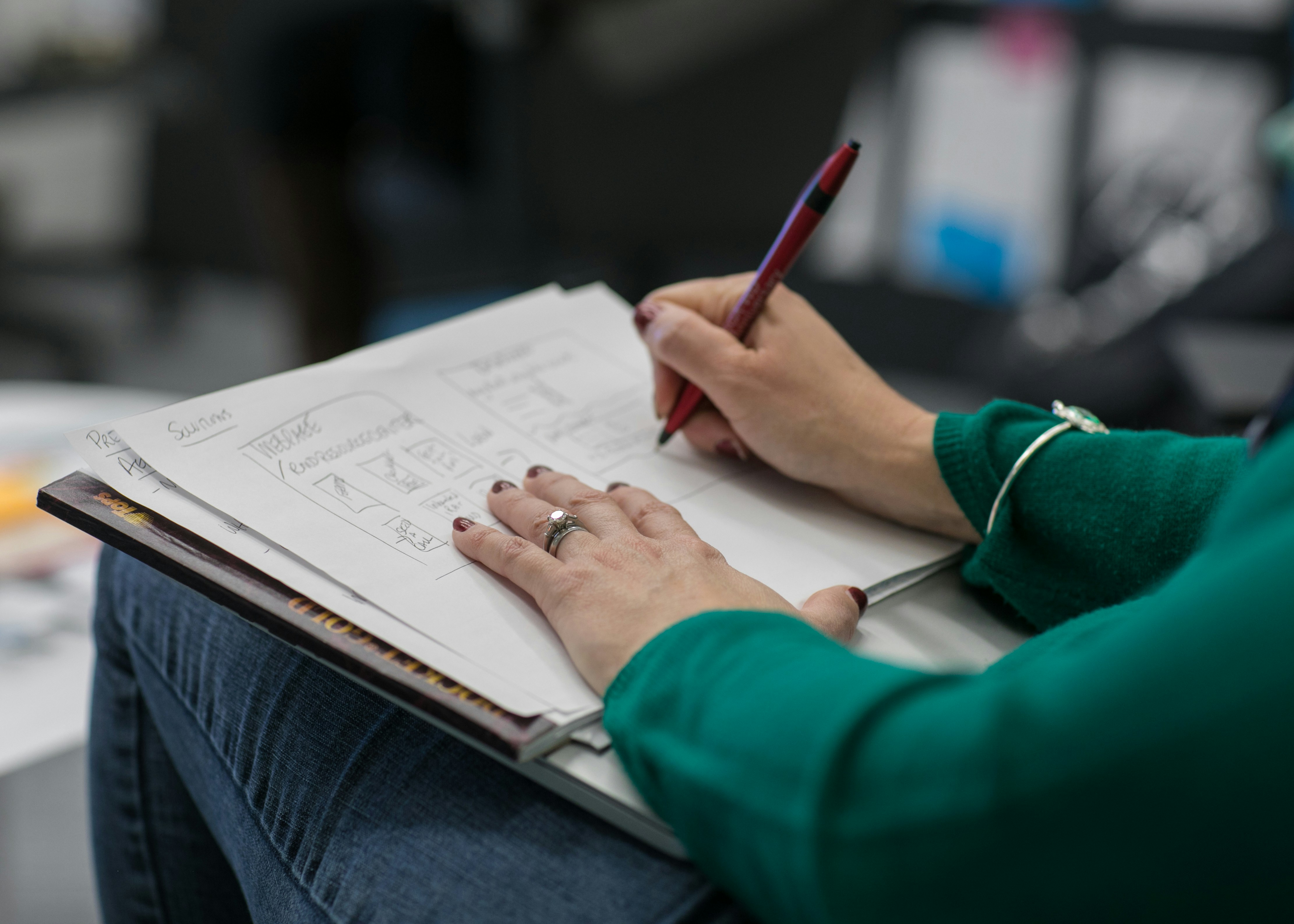 Two hands marking with pen on paper. Photo by Jason Coudriet on Unsplash