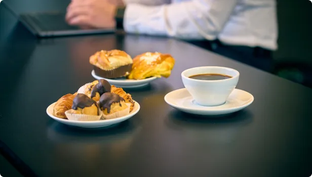 Kaffe och bakverk på ett mötesbord