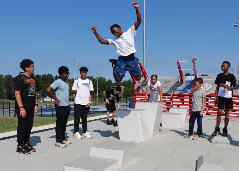High school student jumping over a plyo box during PE class on a Fitness Court