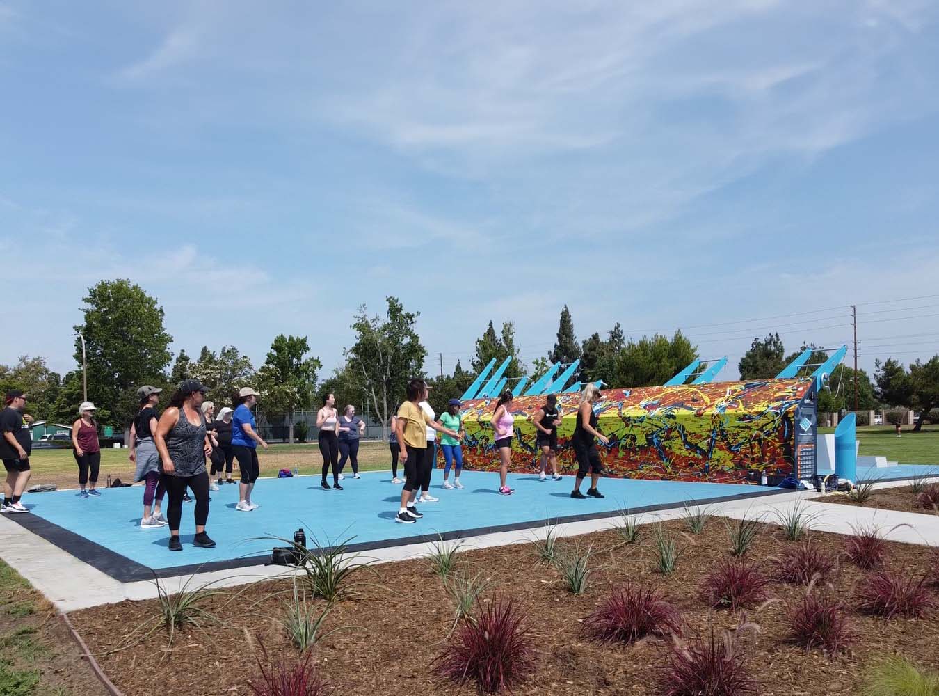 Community members participating in an outdoor group fitness class at a Fitness Court Studio