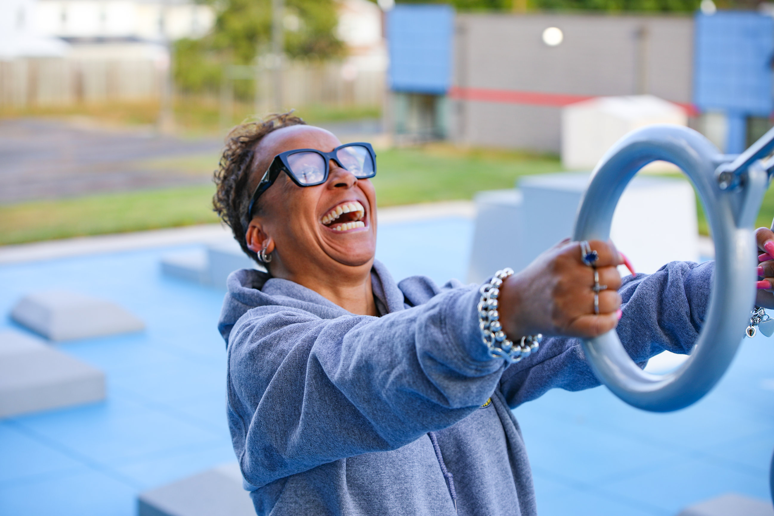 Resident smiling while using the rings at a Fitness Court in a master-planned community