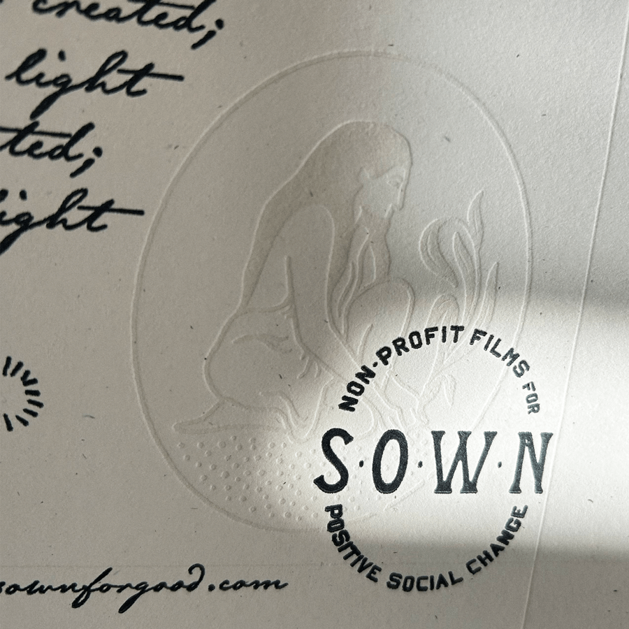 Embossed logo of a person with long hair kneeling and tending to a plant, with text reading 'Non-Profit Films for Positive Social Change' in a circular layout.
