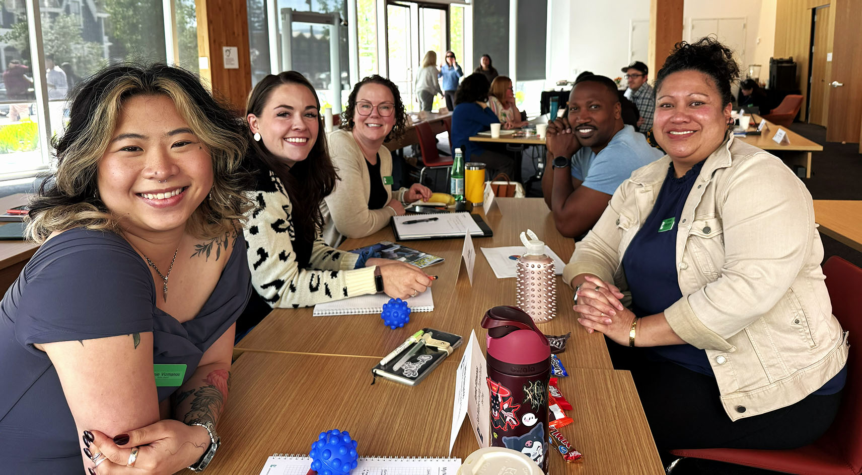 Emerging Leaders Class of 2023 members Lena Silberman, San Mateo County Management Analyst, and Alexa Altamirano, Oncology Registered Nurse at Stanford Health Care, join their a line of classmates as they write out purpose statements on giant Post-It notes during their Opening Retreat, September 2022.