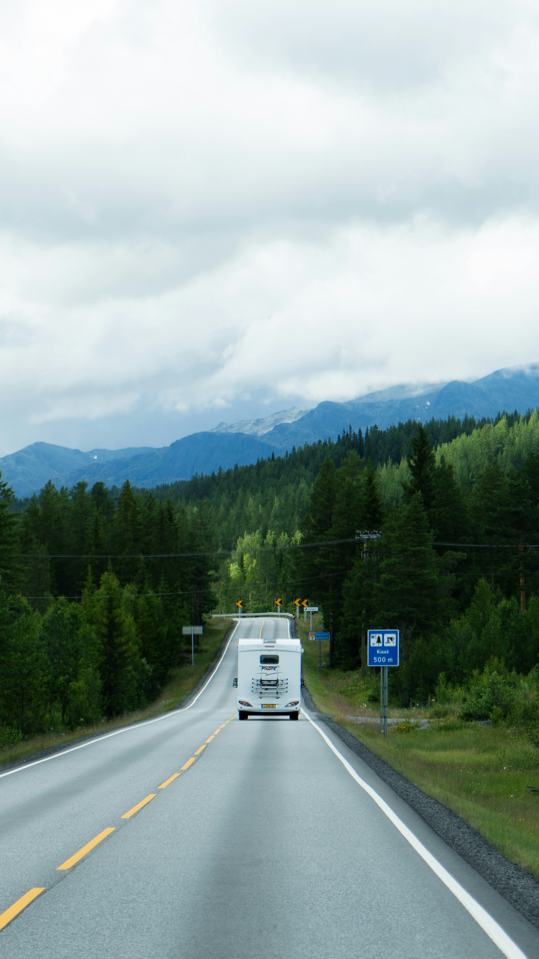 Image of a moving truck on a highway with mountains in the background
