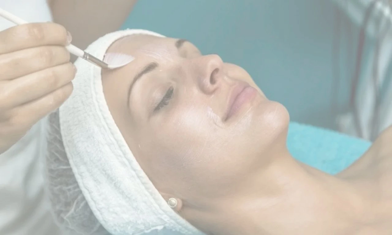 A woman in a white towelling headband looks serene as she receives an Obagi facial peel.