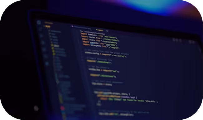 Laptop screen displaying blurred code in a dark-themed code editor with a blue and purple-lit background.