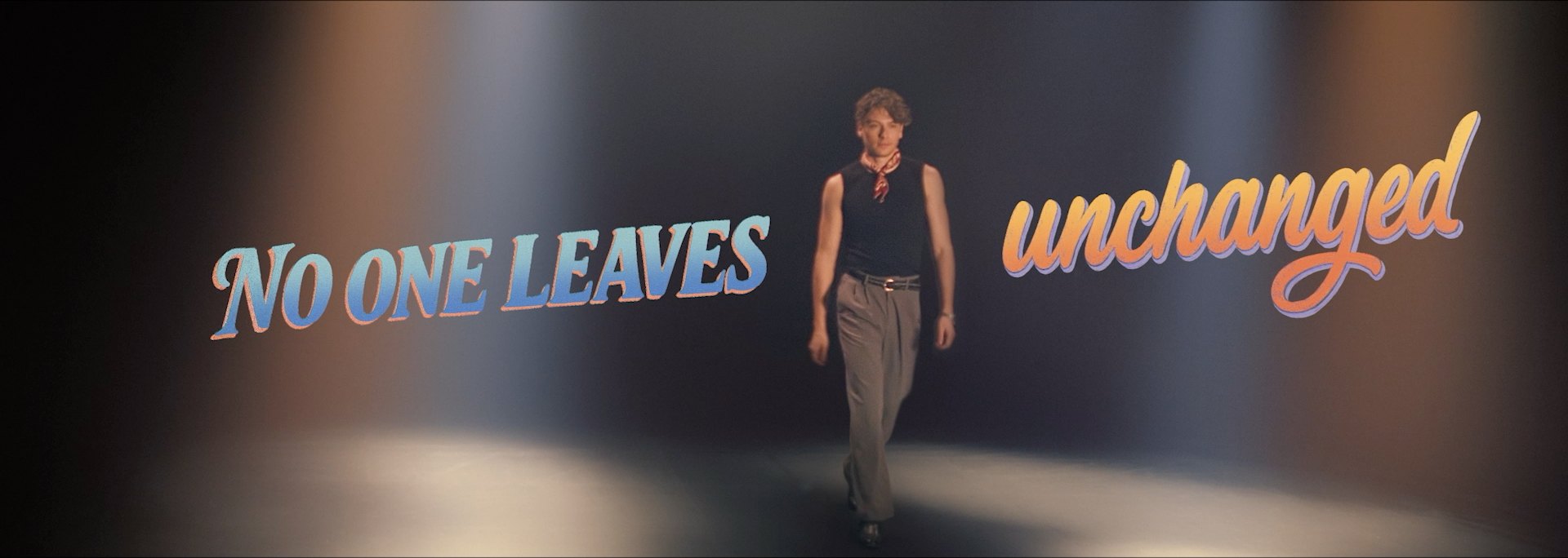 No one leaves unchanged, a man walks through a spotlight