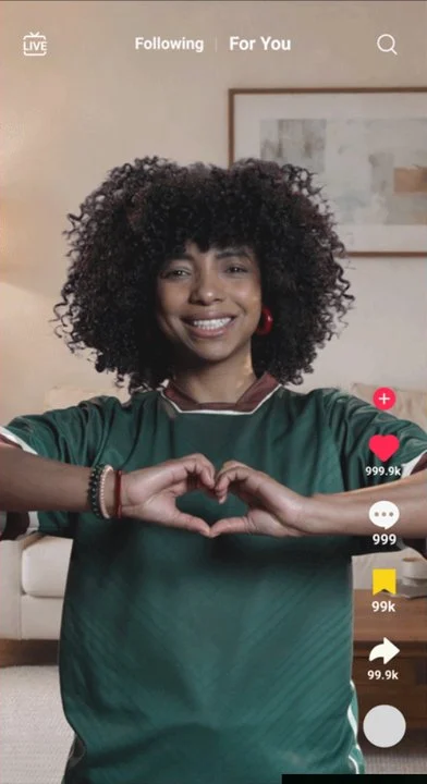 A woman making a heart with her hands on TikTok