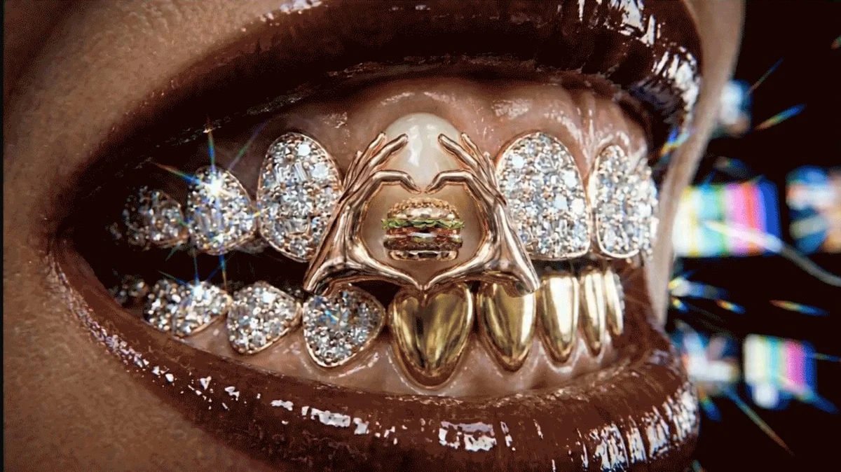 A gold grill with heart hands