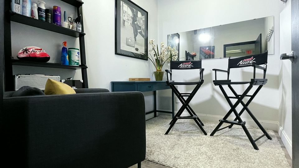 Makeup Room A with a wall mirror, two director's chairs and a sofa.