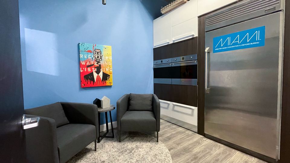 Makeup Room B with a sofa, an armchair and a kitchen with a stainless steel refrigerator.