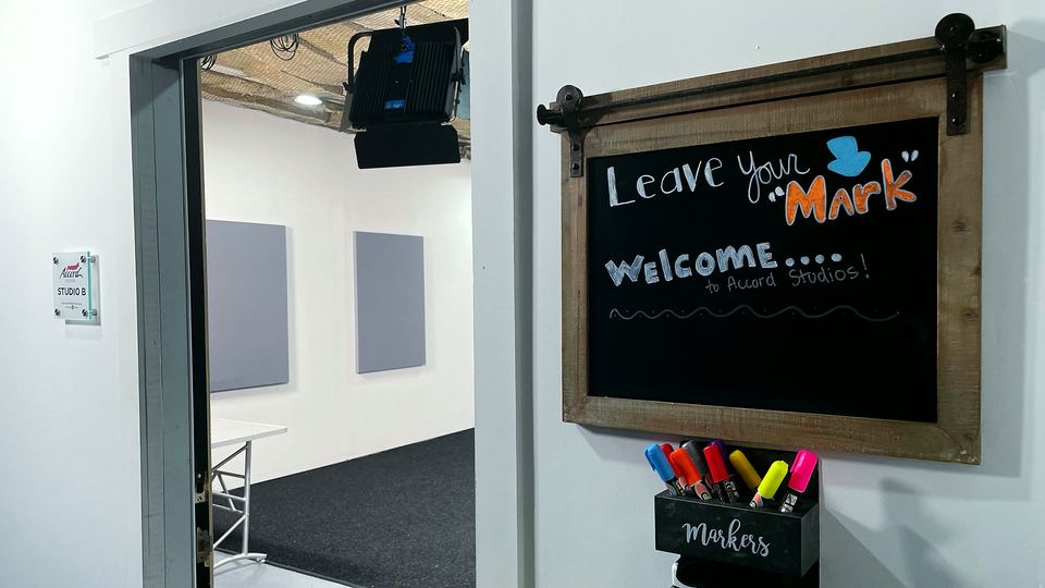 Entrance to Studio B at the Accord Building, with a "Leave your Mark" chalkboard on the wall.