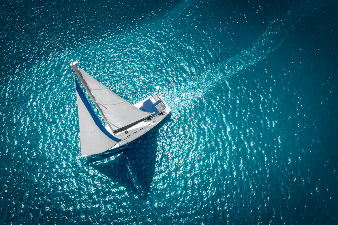 Aerial view of a white sailing yacht on turquoise open water